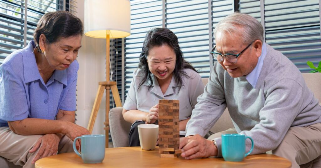 A trio of elderly seniors playing wooden blocks game in a senior daycare, also known as senior enrichment centre