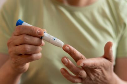 image of an elderly woman pricking her finger for in-home blood test to check sugar level