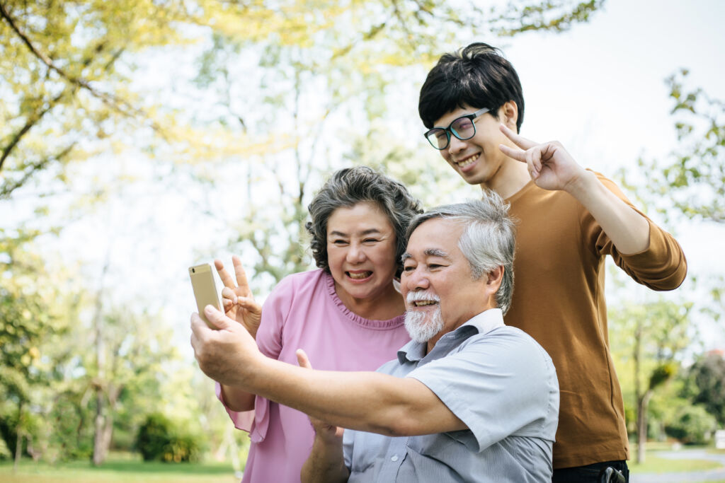 Family with elderly members communicating with others via the mobile phone.