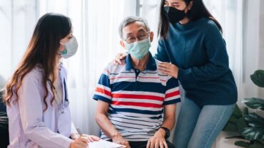 Image of an adult accompanying her elderly parent to consult a doctor. The elderly parent is suspected to be having dementia