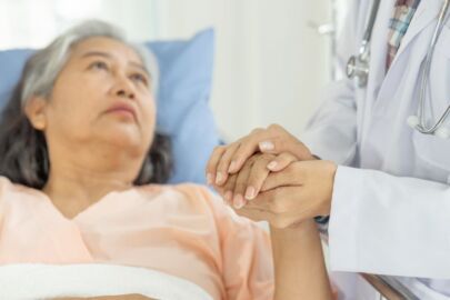 Image of an elderly woman hospitalised and being cared for by medical professionals, either via geriatric, palliative, or rehabilitative care option