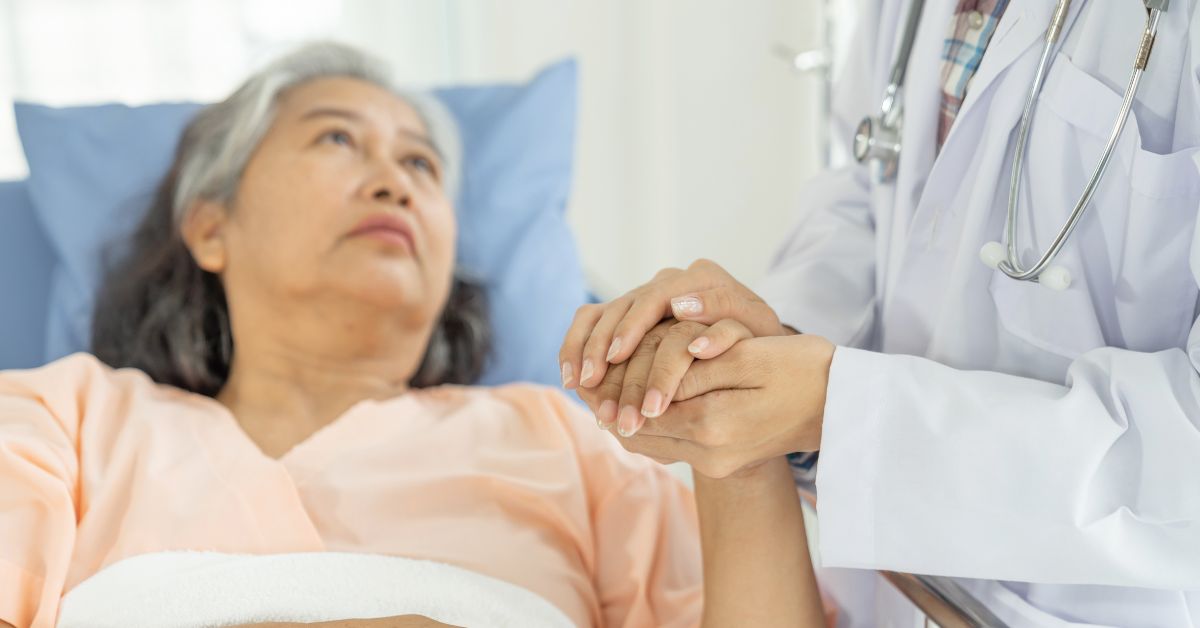 Image of an elderly woman hospitalised and being cared for by medical professionals, either via geriatric, palliative, or rehabilitative care option