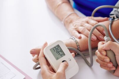 Image of an elderly woman taking her blood pressure reading